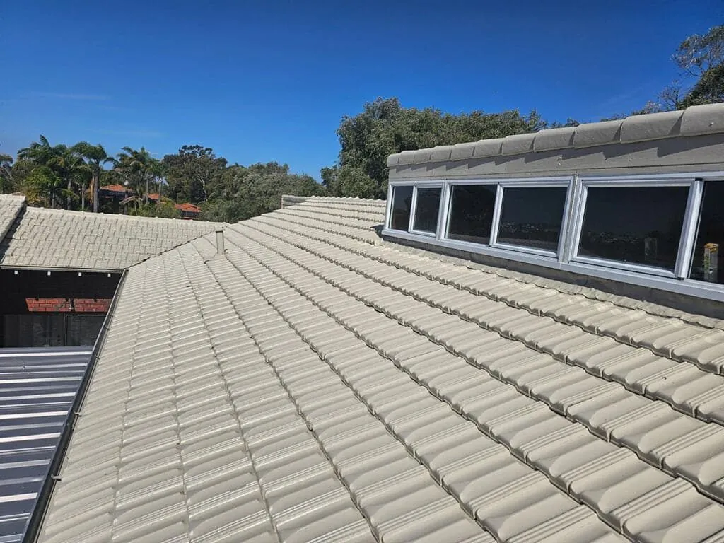 Restored cream tile roof under clear sky on a Perth home