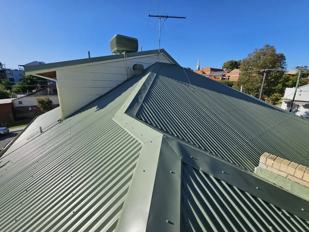 Green Colorbond roof over a Perth home with new gable and eave framing at the rear