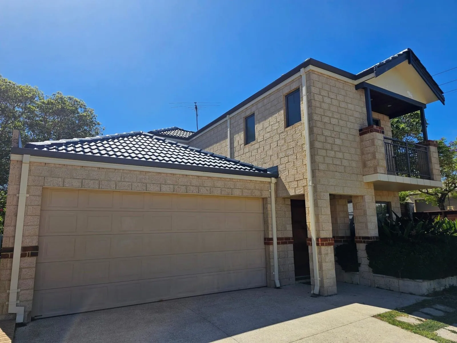 Two storey limestone Perth home with a finished charcoal tile roof and new guttering