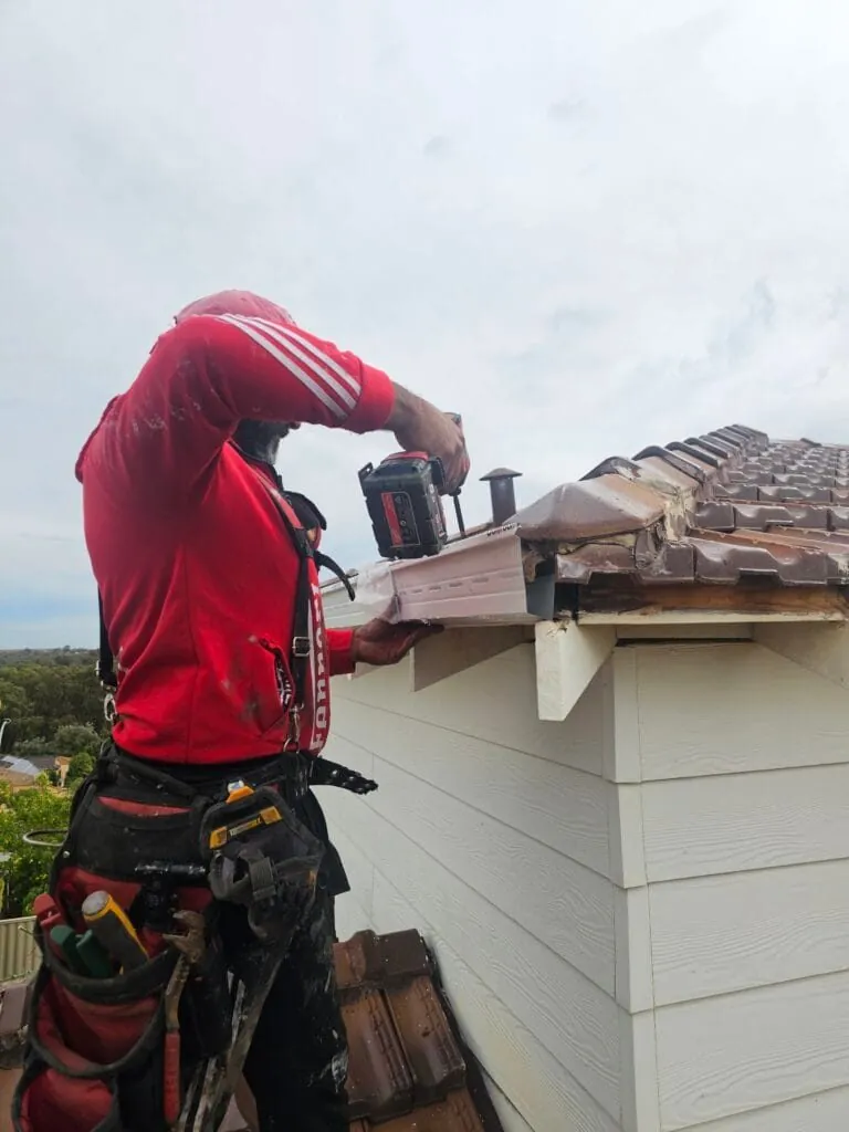 Installer fitting a replacement gutter on a Perth home
