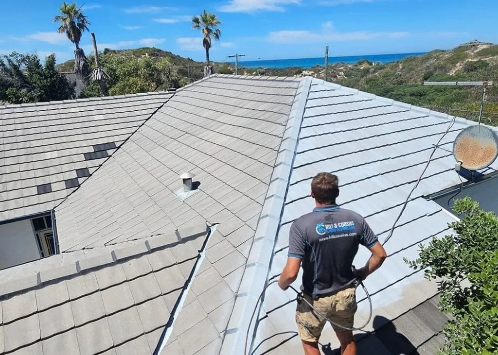 Kili & Cousins roofer spray-coating a cleaned tile roof in Perth