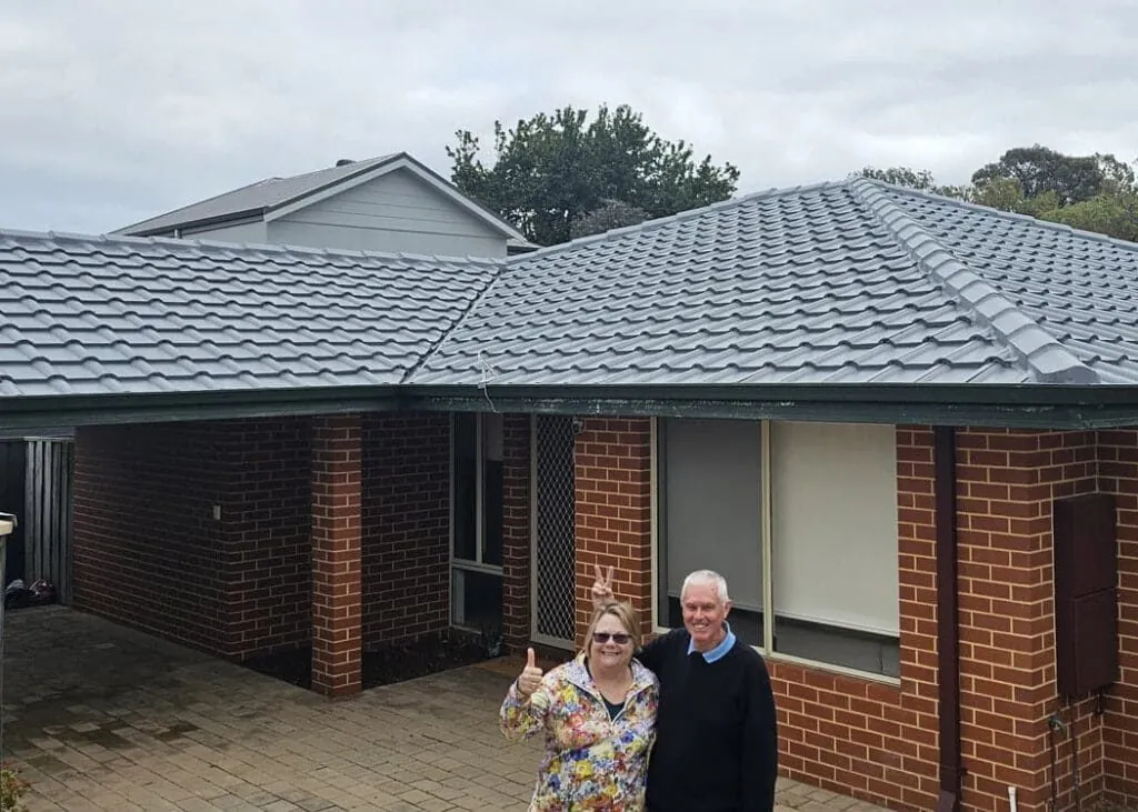 Happy Perth homeowners in front of their freshly restored tile roof