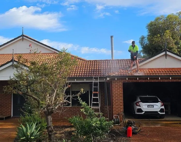 Kili & Cousins roofer high-pressure cleaning a terracotta tile roof on a Perth home