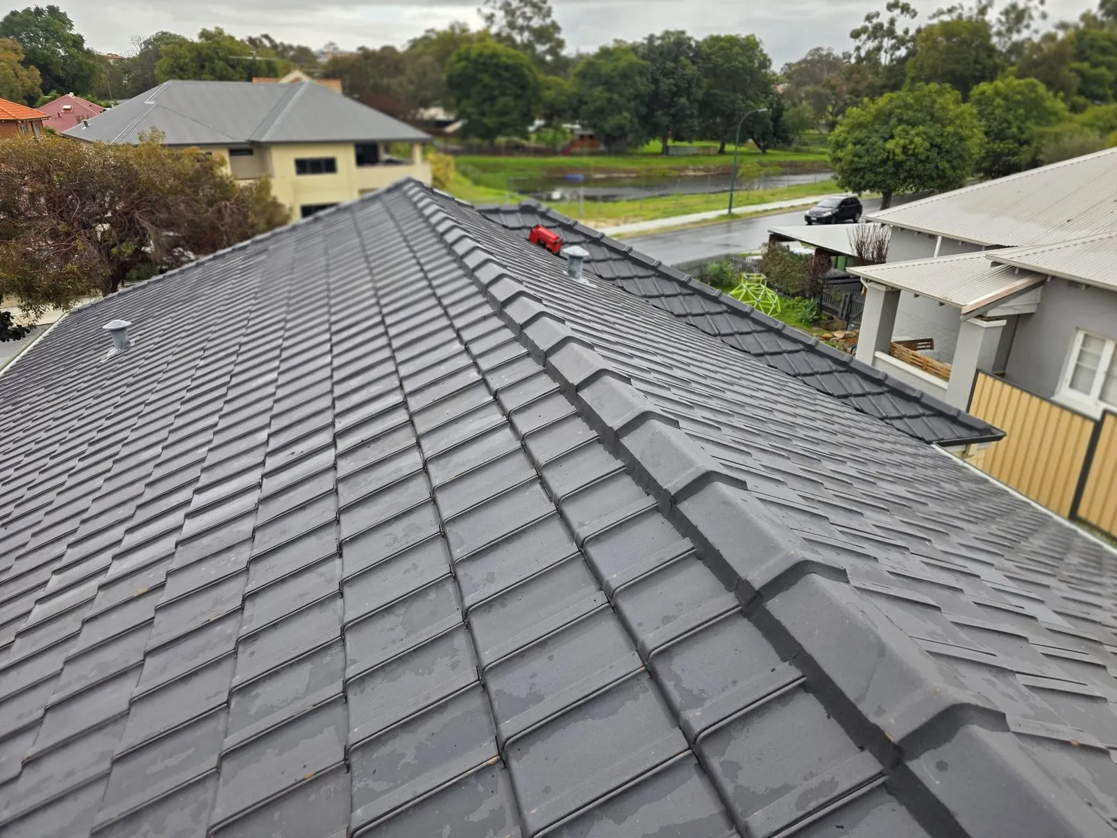 Long ridge line of a cleaned charcoal tile roof in Maylands with fresh pointing run end to end